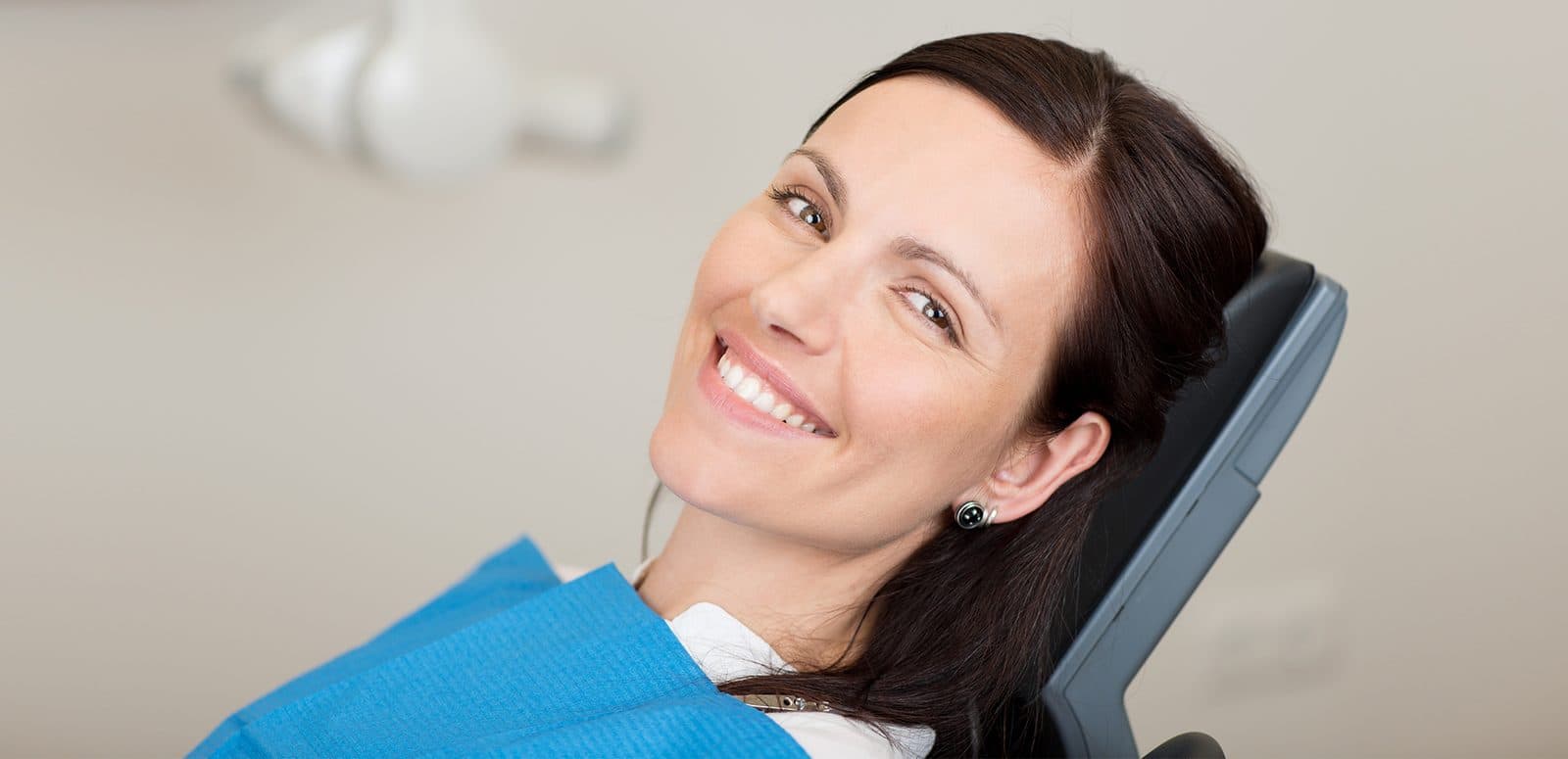 Paciente sorrindo na cadeira odontológica